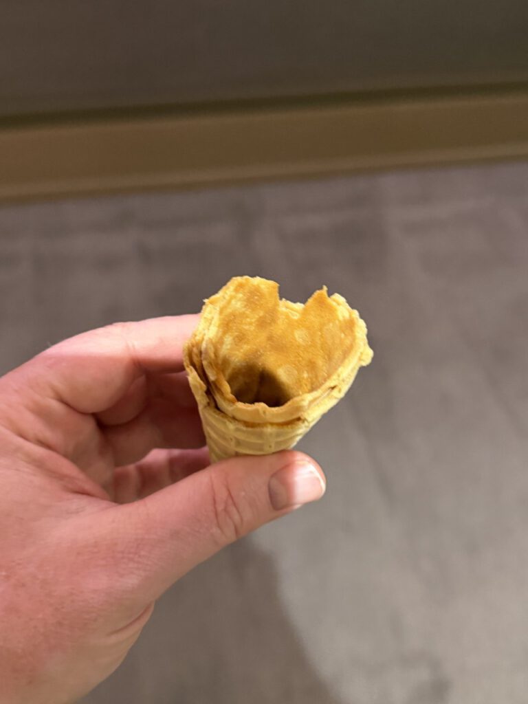 person’s hand holding a partially eaten ice cream cone