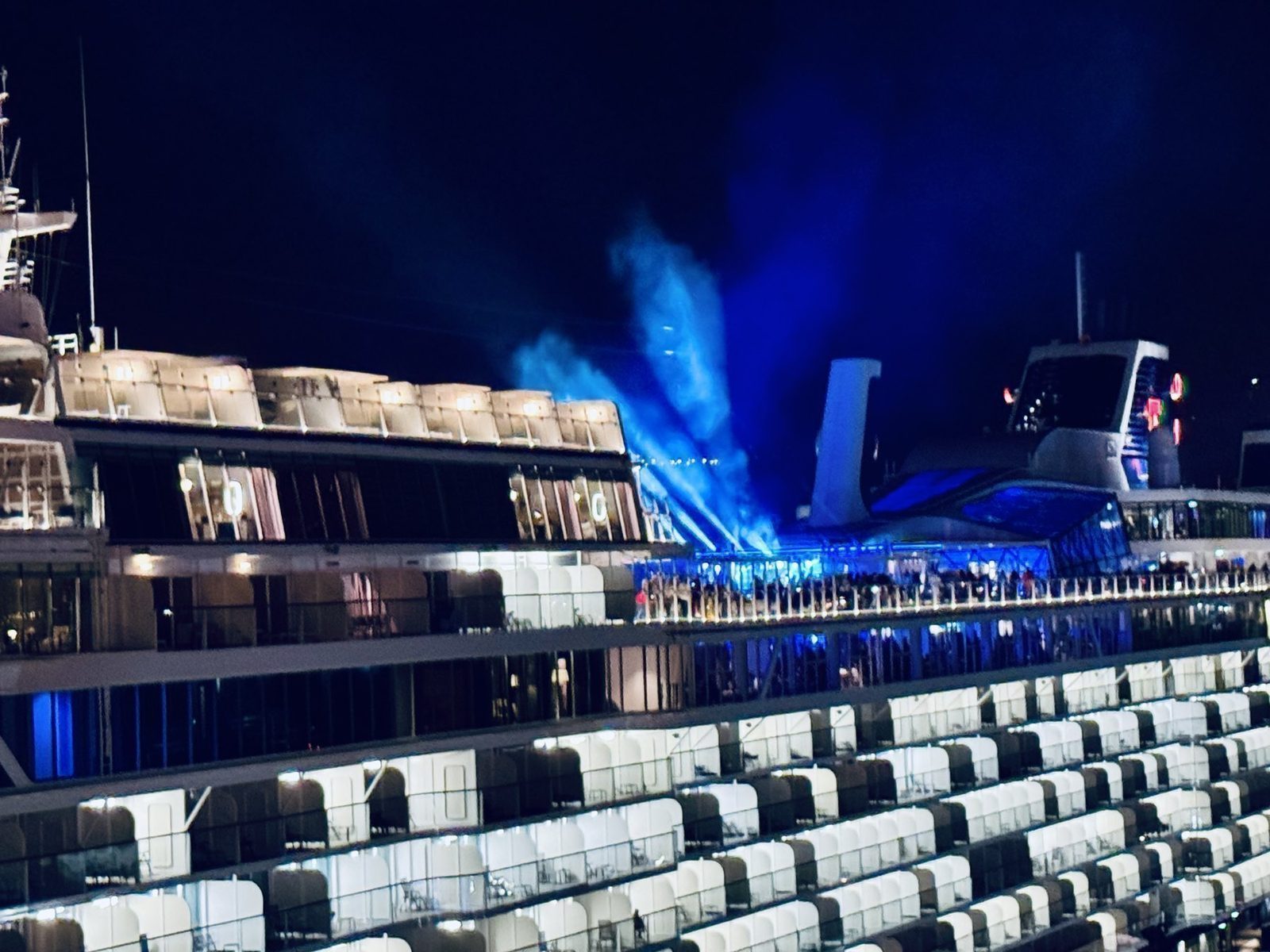 Kreuzfahrtschiff bei Nacht mit blauem Licht