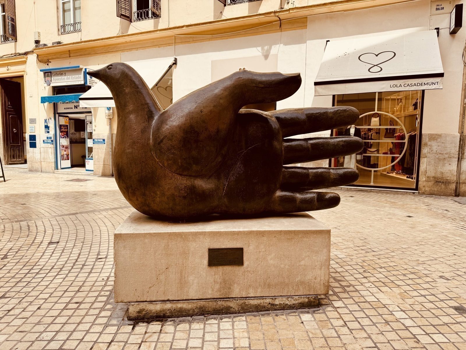 Bronzeskulptur mit Taube in der Stadt