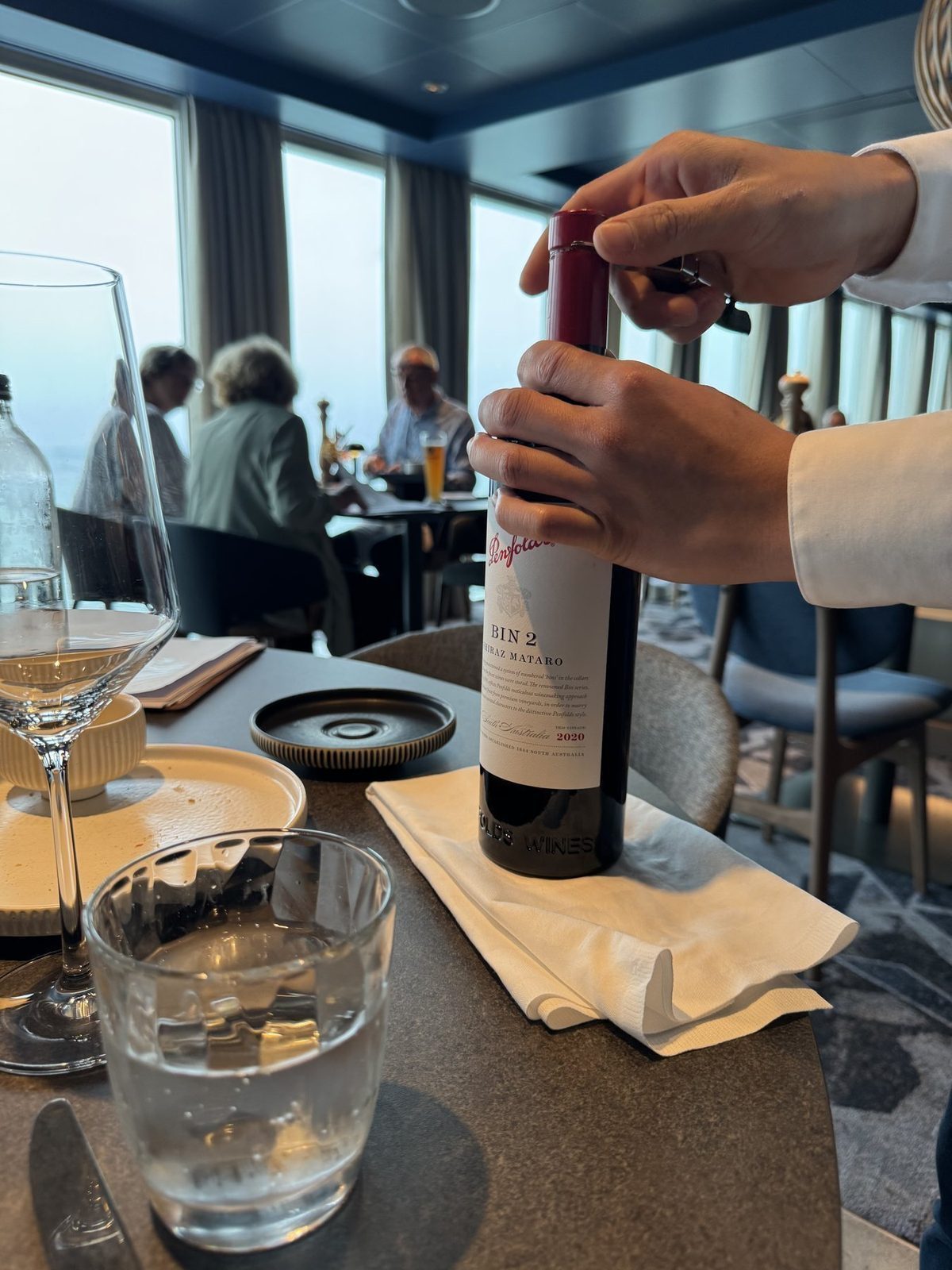 Wirt öffnet Weinflasche im Restaurant