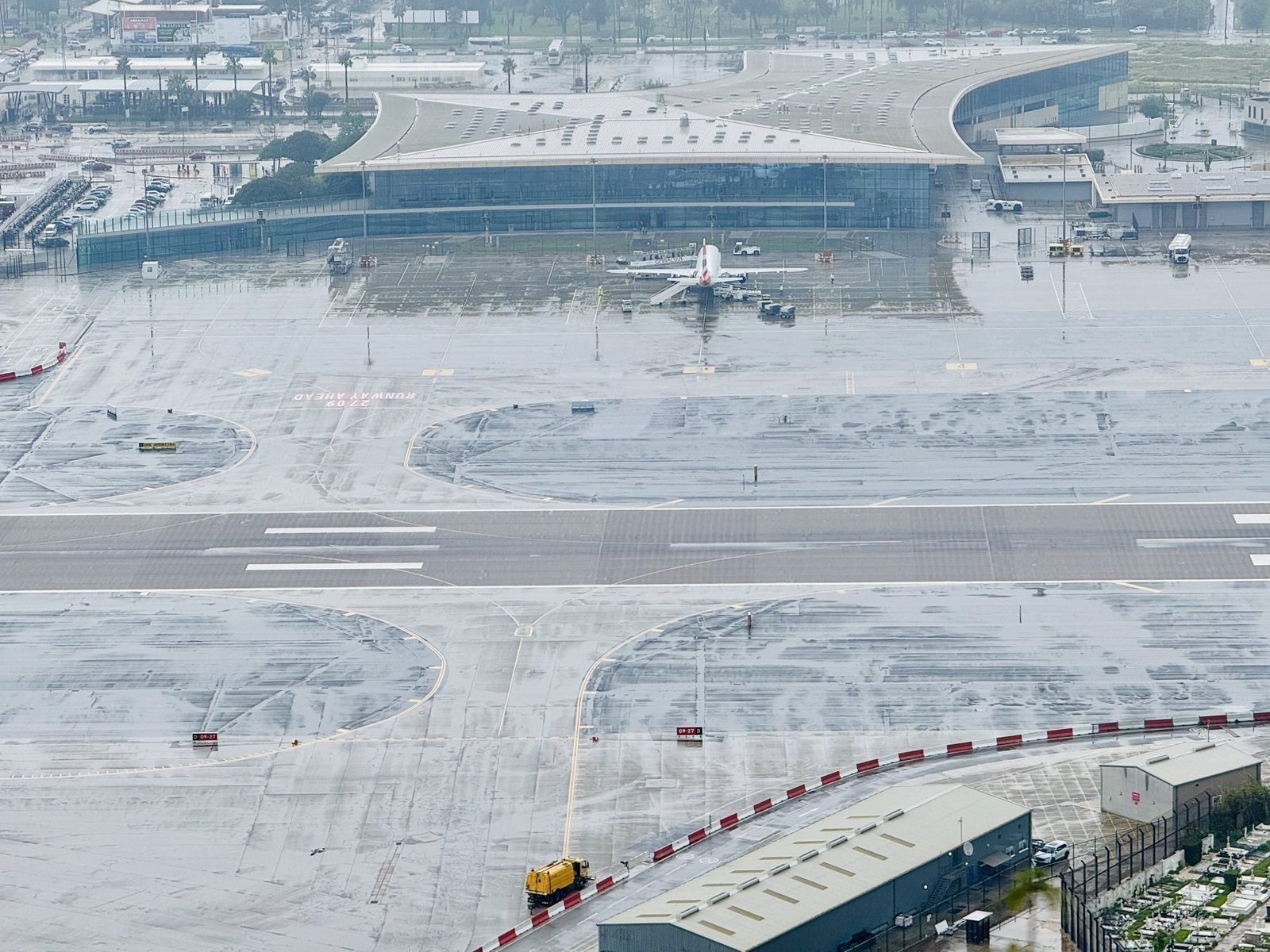 Regnerischer Flughafen mit geparktem Flugzeug