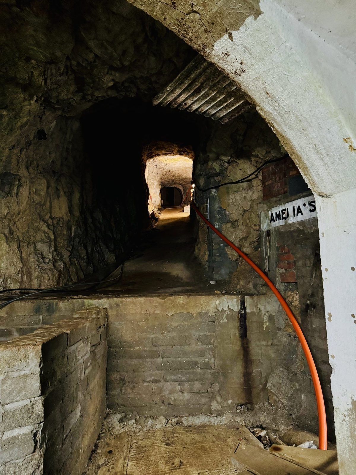 Verlassener Tunnel mit rotem Schlauch