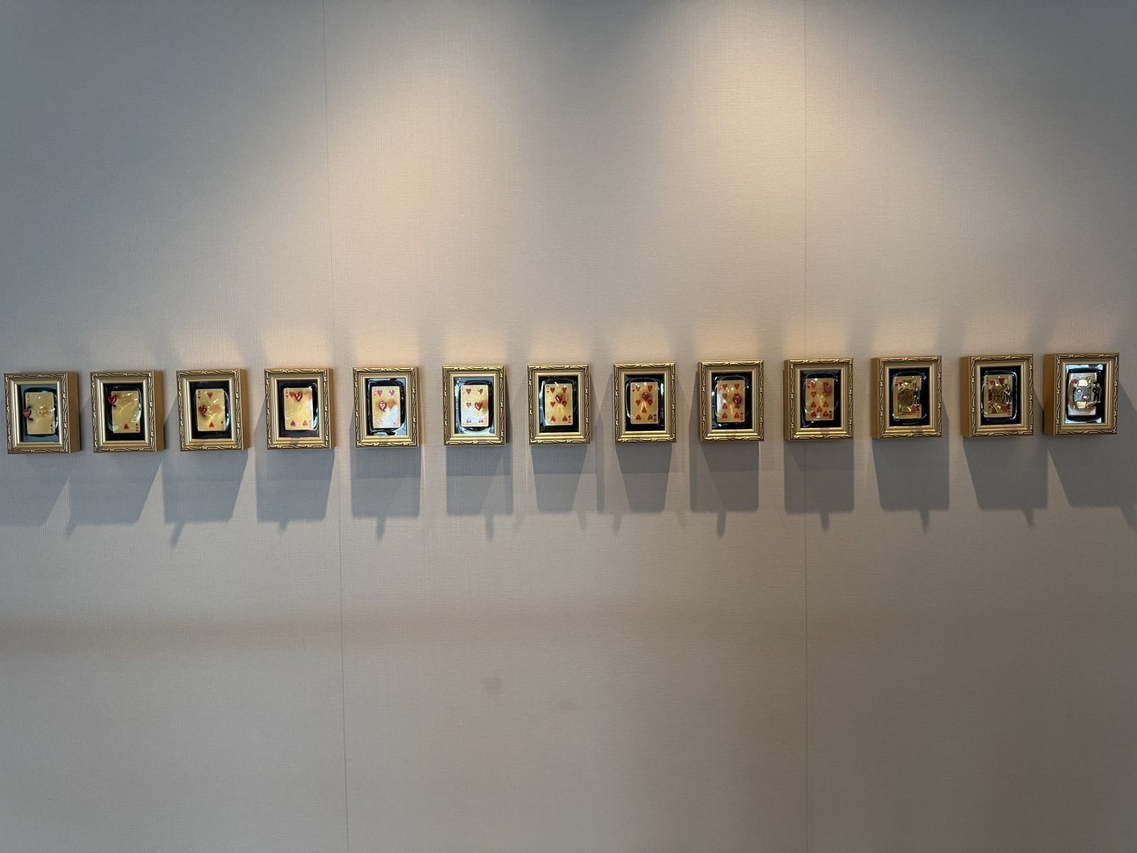 Framed playing cards on gallery wall