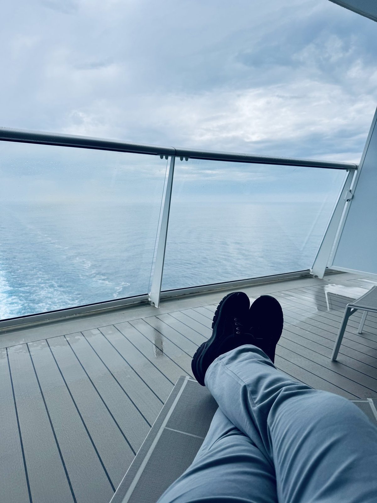 Füße auf dem Balkon mit Meerblick