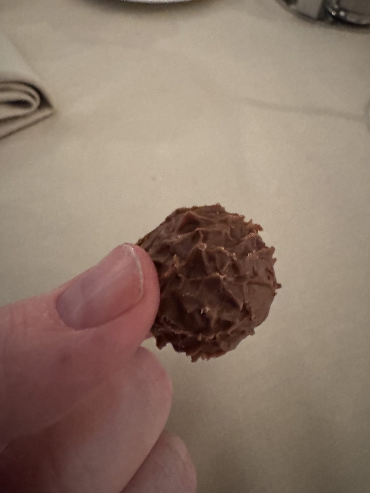 Hand hält Schokoladenbonbon