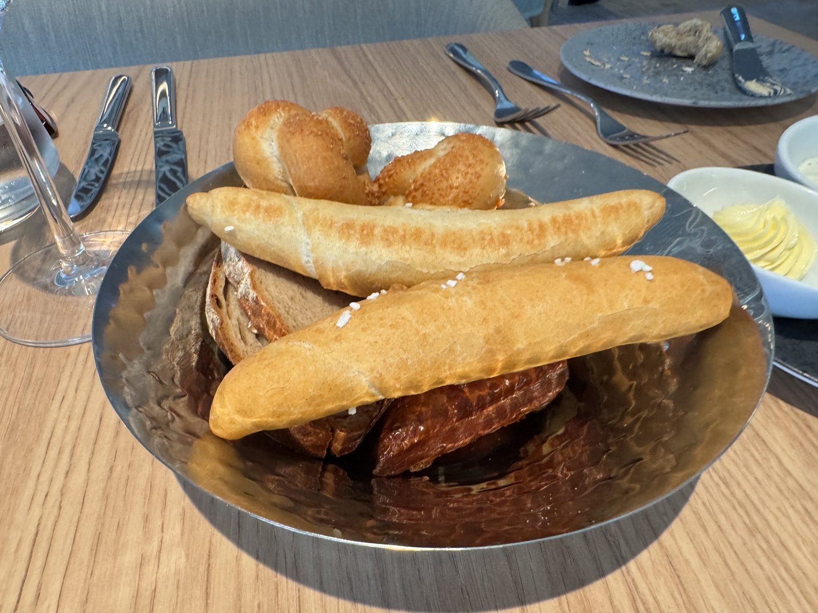 Brot in Metallschale auf Holztisch