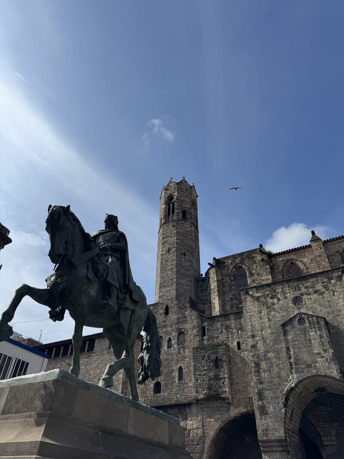 Ein Reiter auf einem Pferd steht im Vordergrund einer historischen Szene mit einer großen gotischen Kirche im Hintergrund