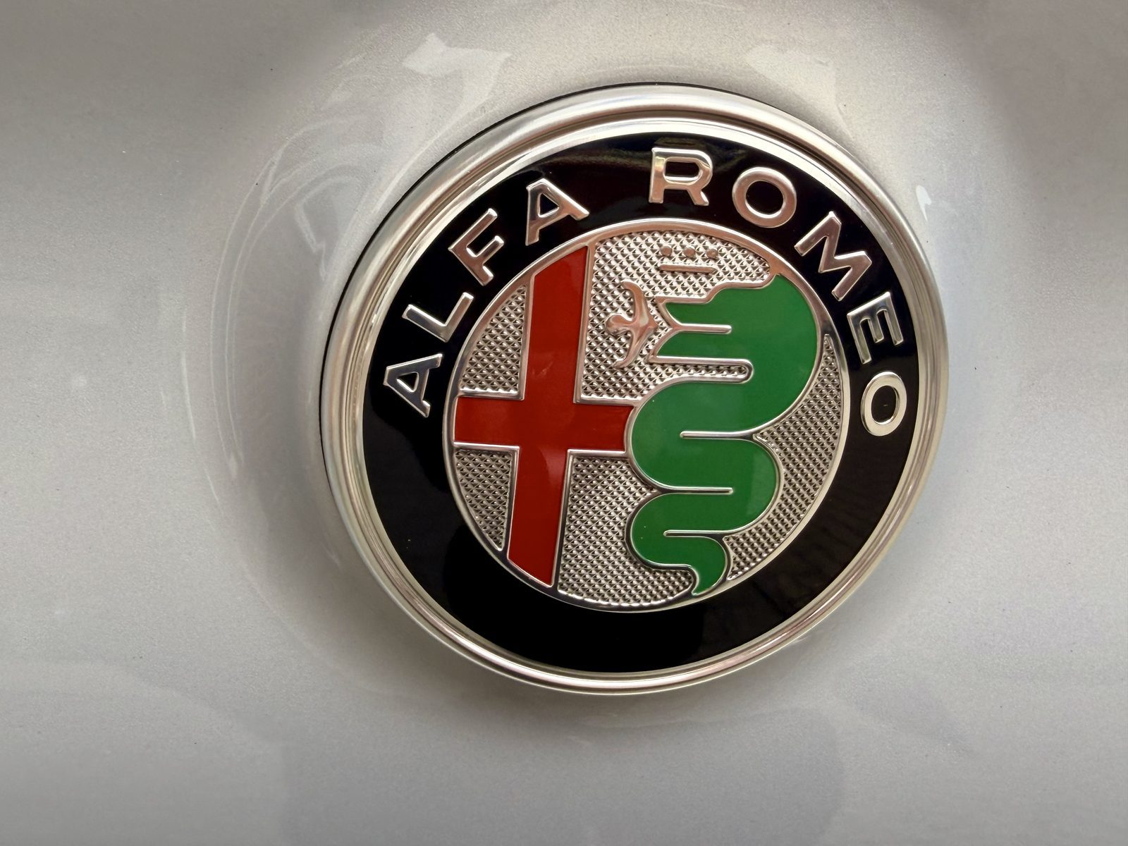 Alfa Romeo Emblem auf glänzendem Auto