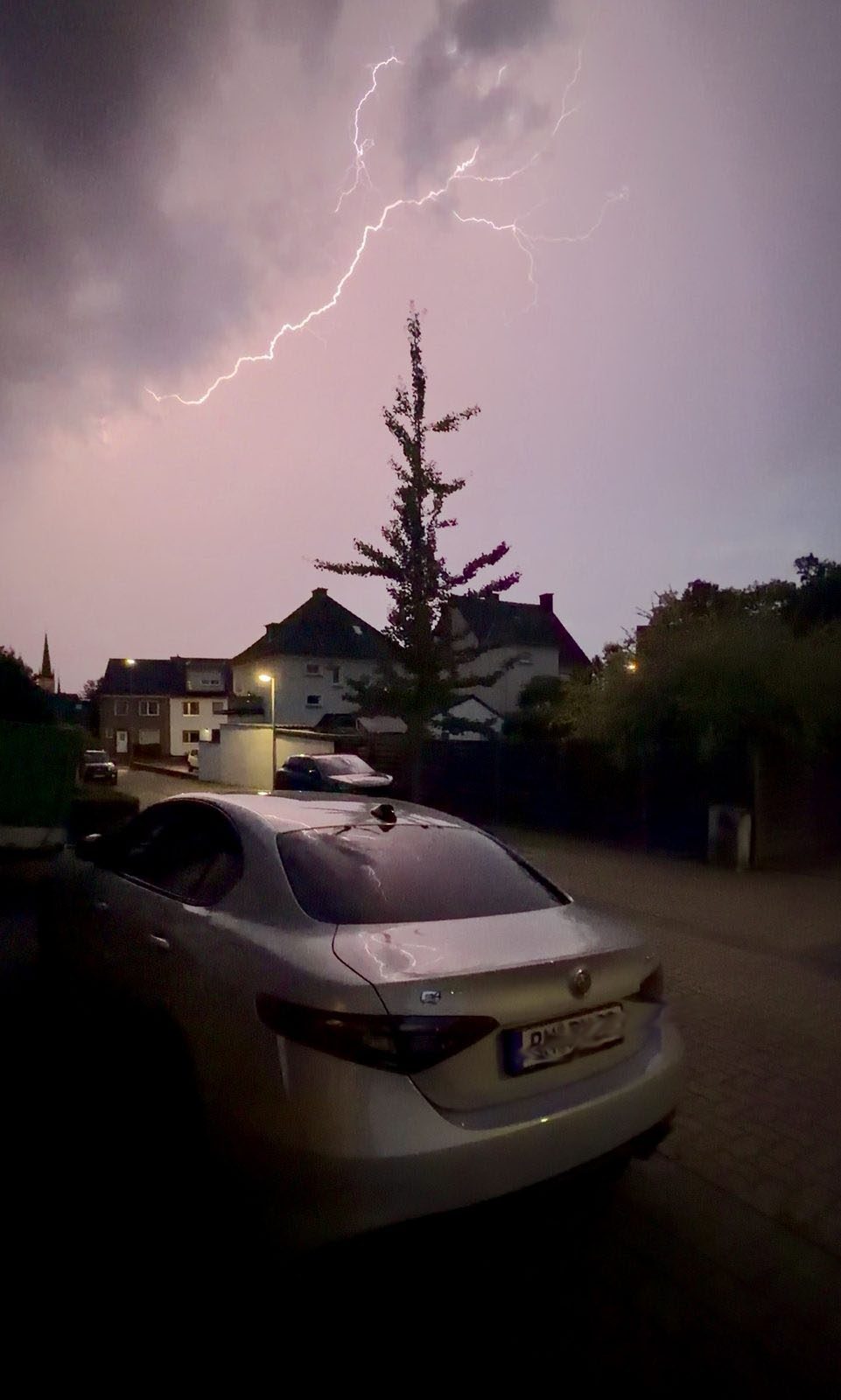 Donner und Blitz über einem Wohnviertel bei Dämmerung