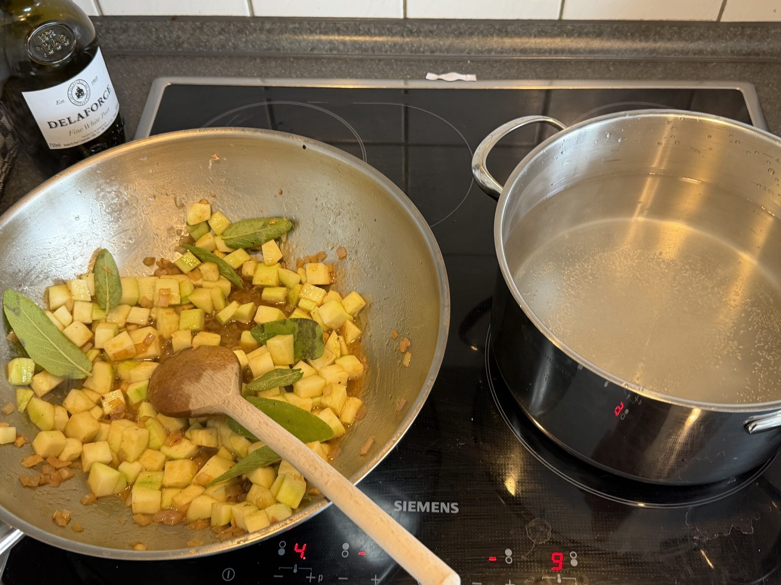 Zwiebeln und Zucchini in Pfanne mit Salbeiblättern alles zusammen rühren