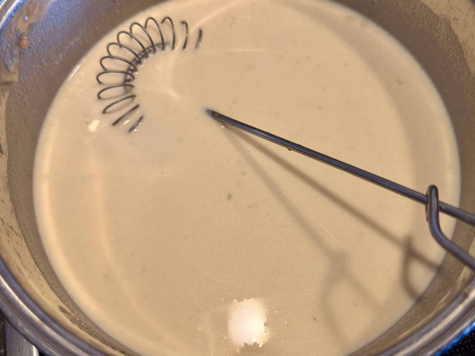 Eine cremige Sauce köchelt in einem Topf