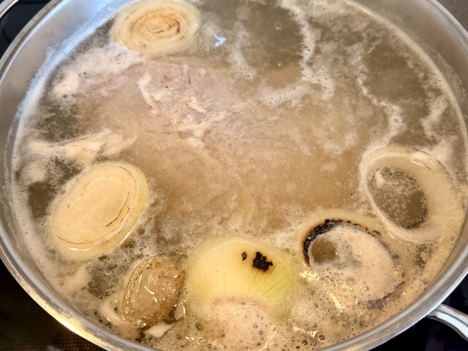 Eine Suppe kocht in einer metallenen Pfanne